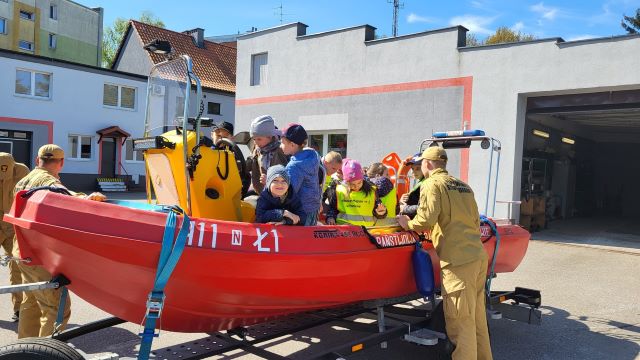 dzieci siedza na lodzi strazackiej