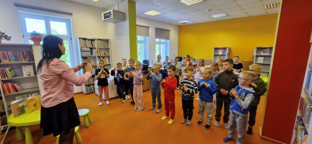 dzieci stoja i pokazuja piosenke