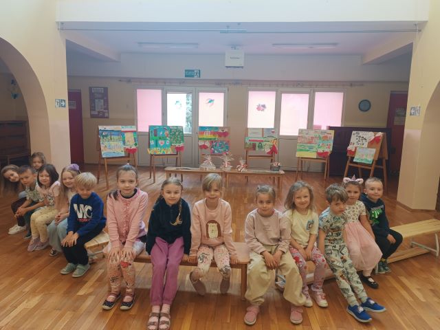 dzieci siedza na lawkach