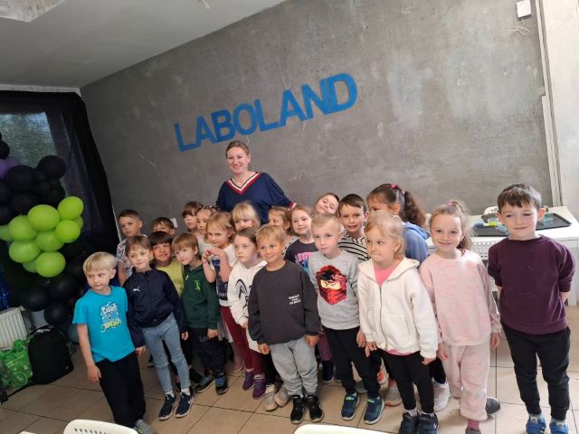 dzieci stoja z pania