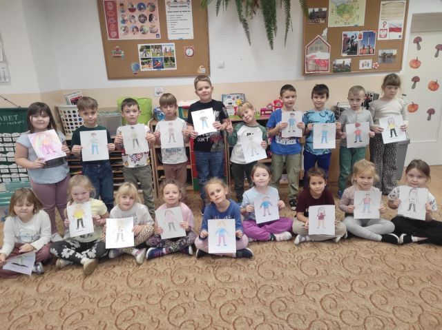 dzieci stoja z kartkami