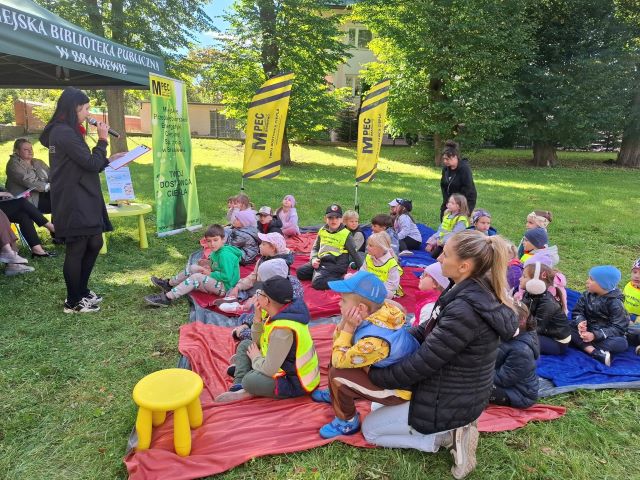 dzieci siedza na trawie